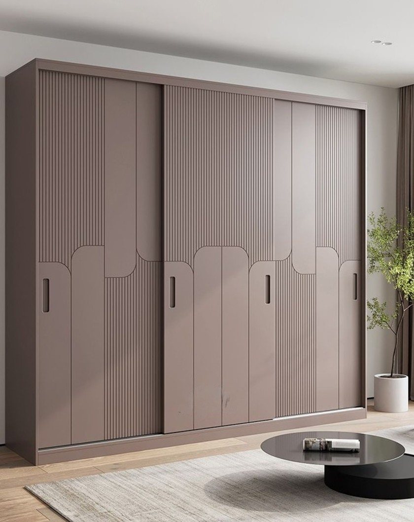 Sliding door wardrobe with ribbed textured panels in warm mauve tone